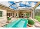 Resort-style pool and patio with covered lanai, outdoor kitchen, and lush landscaping at 3342 Founders Club Dr, Sarasota, FL 34240