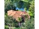 Beautiful aerial view of a house with a tile roof surrounded by lush greenery and overlooking a tranquil pond at 14636 Newtonmore Ln, Lakewood Ranch, FL 34202