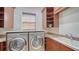 Well-equipped laundry room with modern washer, dryer, and ample storage, perfect for convenience at 14636 Newtonmore Ln, Lakewood Ranch, FL 34202