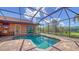 Inviting screened-in pool and spa area featuring an outdoor kitchen and beautiful backyard views at 14636 Newtonmore Ln, Lakewood Ranch, FL 34202