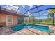 Inviting screened-in pool and spa area with brick pavers and views of the serene surrounding landscape at 14636 Newtonmore Ln, Lakewood Ranch, FL 34202