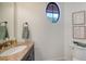 Powder room showcasing a marble countertop, unique round window, and elegant decor at 14636 Newtonmore Ln, Lakewood Ranch, FL 34202