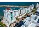 Stunning aerial view of waterfront condos with a picturesque coastal backdrop and palm tree lined street at 226 Golden Gate Pt # 64, Sarasota, FL 34236