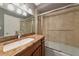 Bathroom featuring granite countertops, wood cabinets, and a tiled shower at 226 Golden Gate Pt # 64, Sarasota, FL 34236