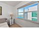 Bedroom featuring tiled floors, neutral walls, a bedside table, and a large window at 226 Golden Gate Pt # 64, Sarasota, FL 34236
