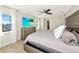 Bright bedroom featuring a tufted headboard, neutral walls, tile flooring, and a ceiling fan at 226 Golden Gate Pt # 64, Sarasota, FL 34236