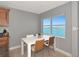 Cozy dining area featuring a white table with seating and a picturesque view of the water from a large window at 226 Golden Gate Pt # 64, Sarasota, FL 34236