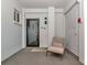 Inviting condo entrance with a cushioned chair and an eye-catching black-framed door at 226 Golden Gate Pt # 64, Sarasota, FL 34236