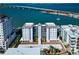 Aerial view showcasing a condo building with bay views and lush landscaping at 226 Golden Gate Pt # 64, Sarasota, FL 34236