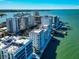 Aerial view of a waterfront condo complex with boat docks and panoramic city views at 226 Golden Gate Pt # 64, Sarasota, FL 34236