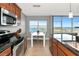 Kitchen featuring stainless steel appliances, dark granite countertops, wooden cabinetry, and a dining area with water views at 226 Golden Gate Pt # 64, Sarasota, FL 34236