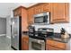 Kitchen featuring stainless steel appliances and wooden cabinets offer a modern and functional cooking space at 226 Golden Gate Pt # 64, Sarasota, FL 34236