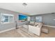 Bright living room with tile floors, gray walls, modern furnishings, and a large TV for a comfortable living space at 226 Golden Gate Pt # 64, Sarasota, FL 34236