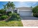 One-story house featuring a paver driveway and lush landscaping at 8512 17Th Nw Dr, Bradenton, FL 34209