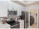 Open concept kitchen with stainless steel appliances and access to laundry at 5160 Northridge Rd # 309, Sarasota, FL 34238