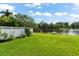 Landscaped backyard with lake view and white fence at 7565 Palmer Glen Cir, Sarasota, FL 34240