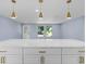 Island kitchen features white cabinets and quartz countertops at 6912 Kenwood Dr, North Port, FL 34287