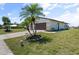 Single story home with a large grassy yard and palm trees at 6912 Kenwood Dr, North Port, FL 34287