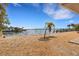 Landscaped waterfront backyard with palm trees and gravel at 1903 Bayshore Dr, Belleair Beach, FL 33786