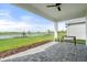 Covered patio with paver stones, a bench, and a view of a pond at 1119 Waterline Ct, Sarasota, FL 34240