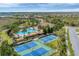 Aerial view featuring tennis courts, pool, community center, and palm tree landscaping within the neighborhood at 317 Acerno Dr, North Venice, FL 34275