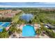 An aerial view shows the pool, community tennis courts, and surrounding lush scenery at 317 Acerno Dr, North Venice, FL 34275