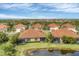 Aerial view of homes with lush landscaping and beautiful pond views in a serene community at 317 Acerno Dr, North Venice, FL 34275