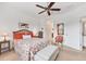 Comfortable bedroom with floral bedding, ceiling fan, neutral walls, and plenty of natural light at 317 Acerno Dr, North Venice, FL 34275