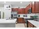 Kitchen with island seating, stainless steel appliances, white countertops, and dark wood cabinetry at 317 Acerno Dr, North Venice, FL 34275