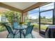 A screened patio with seating, providing a serene view of the tranquil pond and lush greenery at 317 Acerno Dr, North Venice, FL 34275
