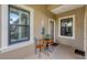Cozy outdoor patio featuring a table with chairs, windows and door with a neutral color scheme at 317 Acerno Dr, North Venice, FL 34275