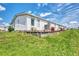 White single-wide home with wooden deck and landscaping at 634 Schooner St, North Port, FL 34287