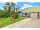 Updated home with a large driveway, shade sail, and lush green grass at 12233 Maryland Ave, Punta Gorda, FL 33955