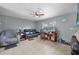 Cozy living room featuring a leather couch, work station, and ceiling fan at 12233 Maryland Ave, Punta Gorda, FL 33955