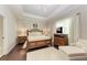 Spacious main bedroom with a large bed, sitting area, and dark wood floors at 12715 Lake Silver Ave, Bradenton, FL 34211