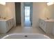 Bright bathroom with double vanities, white cabinets, and a large soaking tub at 705 Anegada Ln, Sarasota, FL 34234