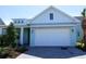Charming, light blue single Gathering home with a pristine white garage door and paver driveway at 705 Anegada Ln, Sarasota, FL 34234