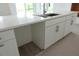 White kitchen island featuring quartz countertops and a stainless steel sink and faucet at 705 Anegada Ln, Sarasota, FL 34234