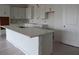 Spacious kitchen island with white cabinets, a stainless steel sink and quartz countertops at 705 Anegada Ln, Sarasota, FL 34234