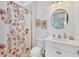 Cozy bathroom features a floral shower curtain and white vanity at 8175 Redonda Loop, Lakewood Ranch, FL 34202