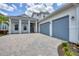 Charming two-story home featuring blue accents, a paver driveway and a three-car garage at 8175 Redonda Loop, Lakewood Ranch, FL 34202