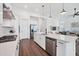 Open-concept kitchen with stainless steel appliances, quartz countertops, and hardwood floors at 8175 Redonda Loop, Lakewood Ranch, FL 34202