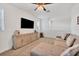 Neutral living room with wall-mounted television and soft couch at 8175 Redonda Loop, Lakewood Ranch, FL 34202