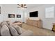 Neutral living room with wall-mounted television and soft couch at 8175 Redonda Loop, Lakewood Ranch, FL 34202