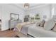 Light and bright main bedroom with grey wood-look floors, dresser, and neutral decor at 8175 Redonda Loop, Lakewood Ranch, FL 34202