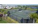 Aerial view of fenced tennis courts with shade structure and palm trees at 8175 Redonda Loop, Lakewood Ranch, FL 34202