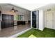 Modern kitchen with dark cabinetry and access to an outdoor patio at 235 Cocoanut Ave # 113C, Sarasota, FL 34236