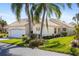 Single story home with tile roof, palm trees, and well-manicured lawn at 1350 Capri Isles Blvd # 54, Venice, FL 34292