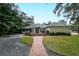 Brick pathway leads to the charming yellow house with a large backyard at 1585 South Dr, Sarasota, FL 34239