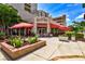 Outdoor seating area of a restaurant with red umbrellas and brick planters at 12357 Nantahala Run, Parrish, FL 34219